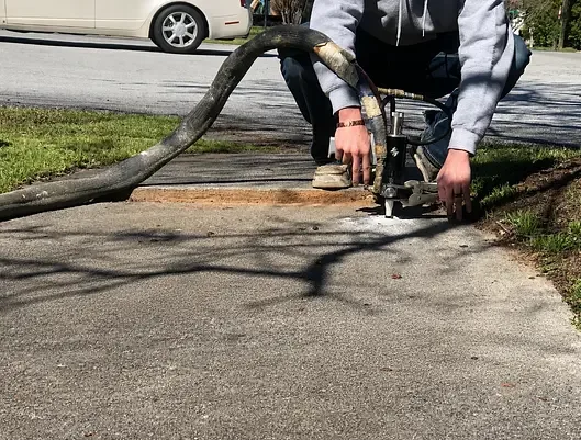 Equipment injecting polyurethane beneath a concrete slab