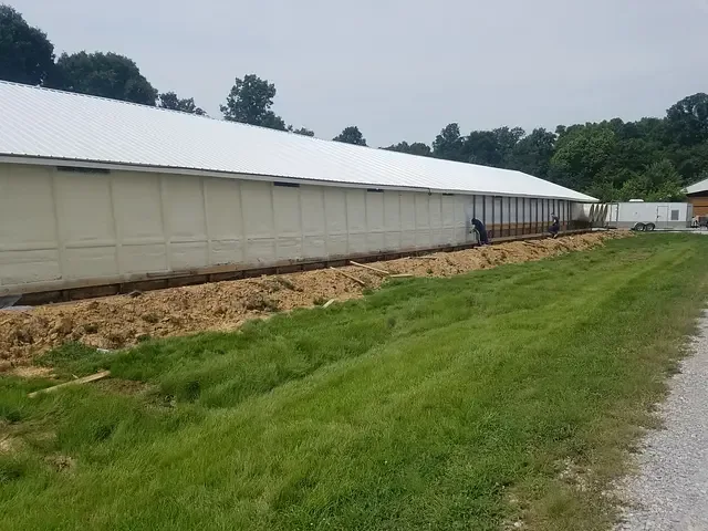 Metal farm building beside a grassy field