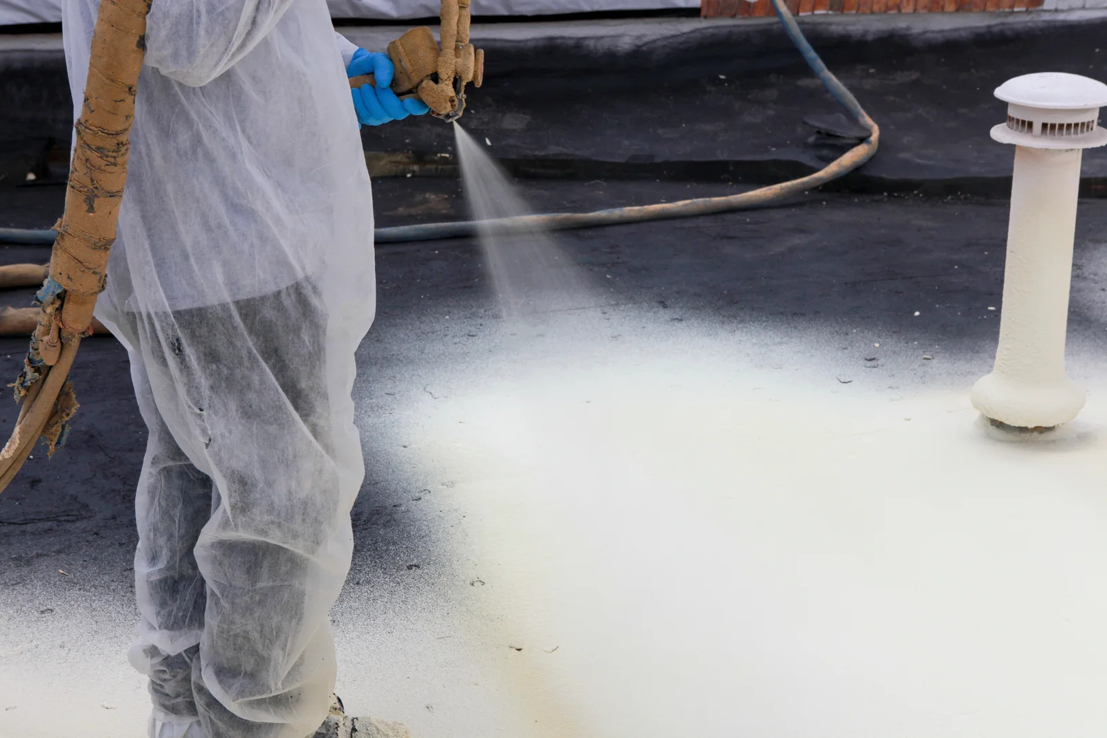 Spray foam being applied to a low-slope roof