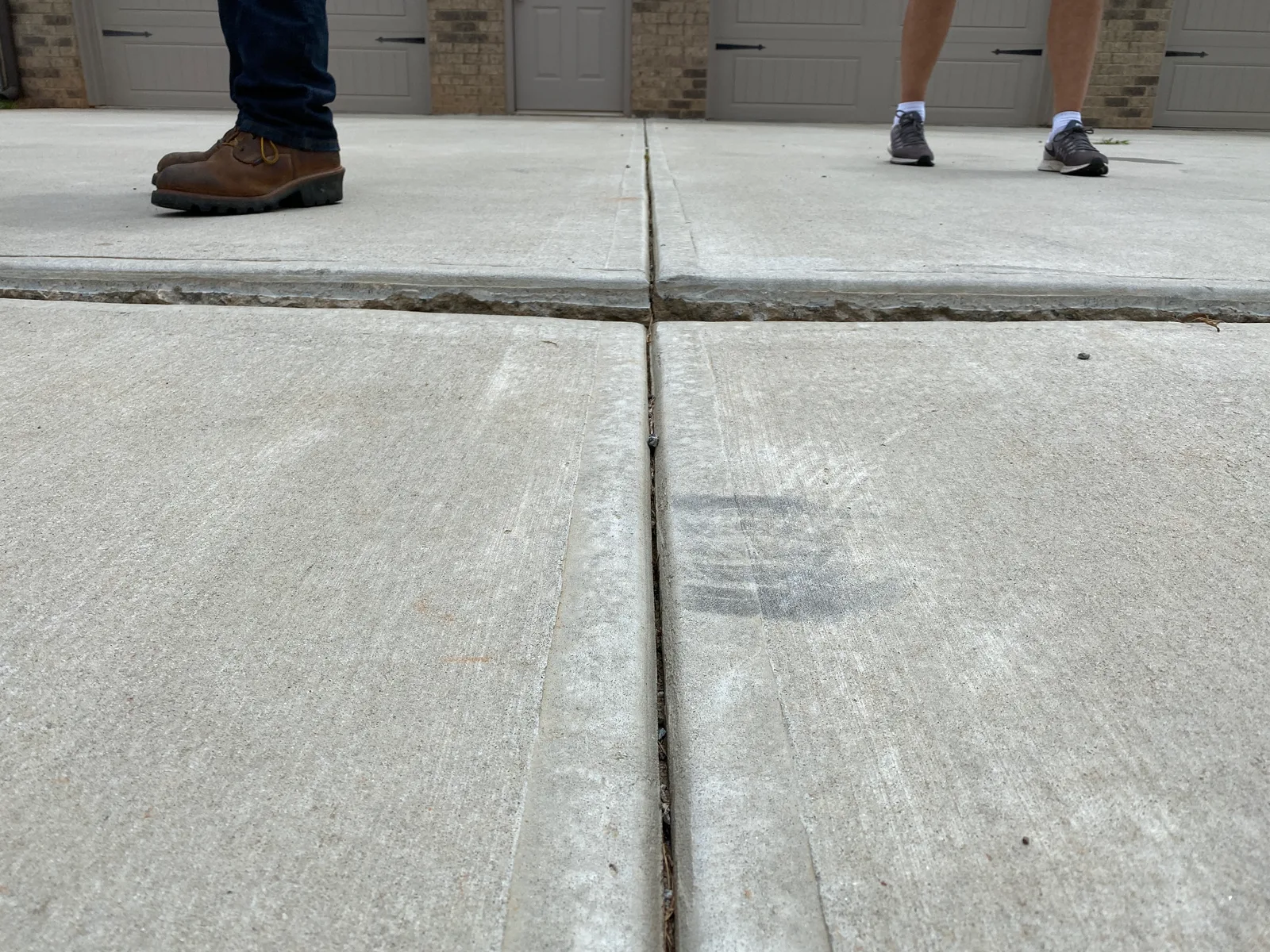Settled driveway slab at a garage transition