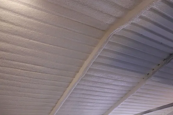 Spray foam insulated roof of a metal building